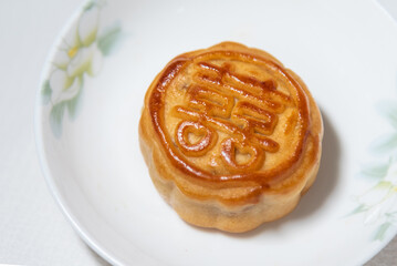 Chinese traditional food , pie with chinese character for happiness , betrothal gift , mooncake on plate