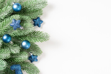 Christmas background. Blue decorations on spruce branches on a white background. Christmas Flatly. Top view from copyspace