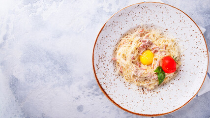 Pasta alla carbonara with bacon, egg, parmesan cheese and cream sauce. Classic Italian food. Top view. Text space