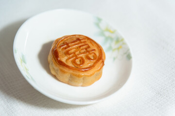 Chinese traditional food , pie with chinese character for happiness , betrothal gift , mooncake on plate