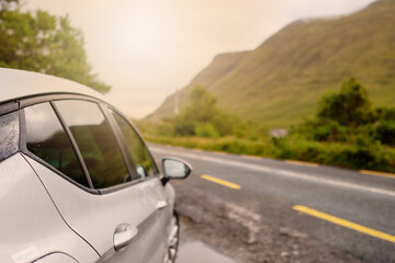 Car side in focus, Road and mountains in the background out of focus. Concept road trip, Connemara, Ireland