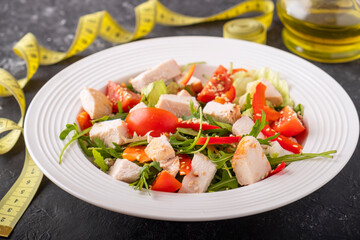 Salad with chicken, cherry tomatoes, red pepper and arugula. Diet concept. Closeup