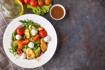 Tasty salad with chicken, mozzarella, arugula and cherry tomatoes. Top view, text space