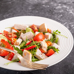 Salad with chicken, cherry tomatoes, red pepper and arugula. Healthy food concept. Lifestyle