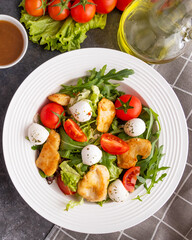 Chicken, mozzarella, arugula and cherry tomatoes on a plate. Healthy and diet food concept. Top view