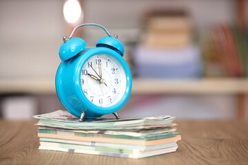 Alarm clock on a stack of banknotes