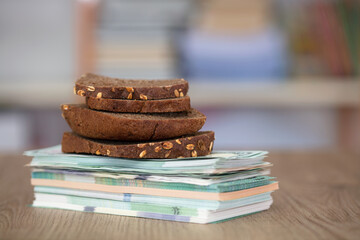 Several pieces of black bread on a stack of banknotes