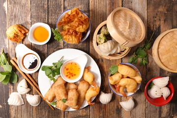selection of asia food- spring roll, dim sum, fries shrimp and sauce