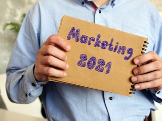 Financial concept meaning Marketing 2021 with phrase on the piece of paper.