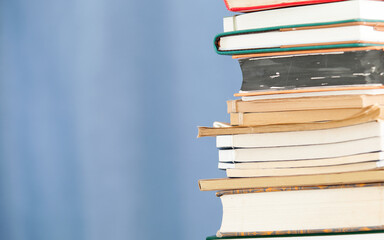 Stack of books in front of blue background