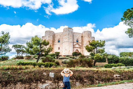 Exterior view of the octagonal "Castel del Monte" (Castle of the Mountain), 13th-century citadel and castle built by Emperor Frederick II, with tourist taking a photo, near Andria, Puglia, Italy. 