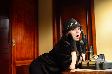 Girl talking on an old dial telephone and surprised