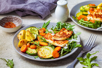 Grilled halloumi cheese with grilled vegetables on gray plate. Vegetarian food concept.