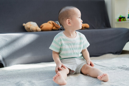 A little boy sitting on the carpet reading an early childhood picture book