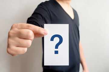 Man holding white card with question mark symbol