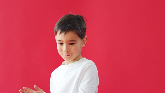 Young casually dressed boy doing robot dance against red studio background  - shot in slow motion