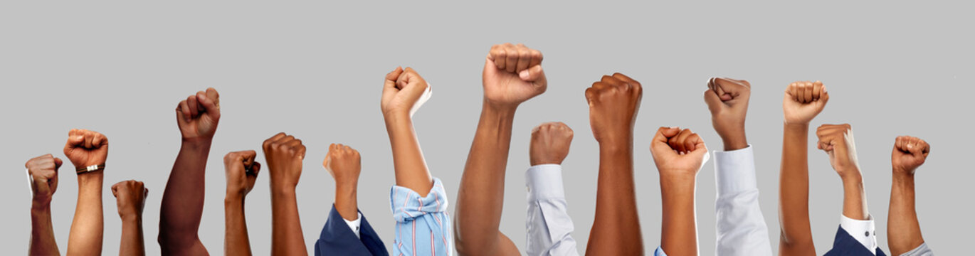 civil rights, equality and power concept - african american male hands showing fists over grey background