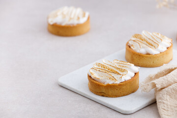 Tartlets with whipped cream close up on white marble kitchen table