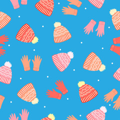 Doodle bright orange and pink gloves, wool hats, white dots on blue background. Seamless winter clothes pattern. Suitable for packaging, textile, wallpaper.