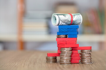 Dollar bills raised by building blocks indoors