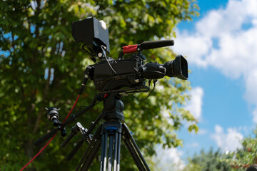 Video camera - Ready for recording show in outdoor TV studio - focus on camera aperture