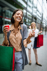 Shopping and tourism concept. Beautiful women friends with shopping bags in ctiy