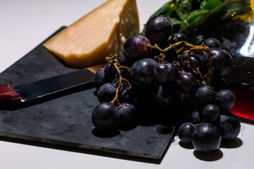 Minimal food composition of wine, grape and parmigiano (italian cheese) on a white background. Fresh fruit and cheese and a tasty italian wine. Healthy and traditional italian food.
