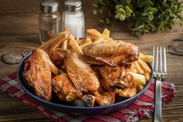 Baked chicken wings with french fries.
