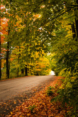 Empty country road in rural New England during Autumn with foliage changing to fall colors creating a tranquil contemplative scene