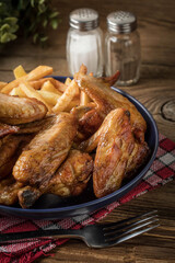 Baked chicken wings with french fries.