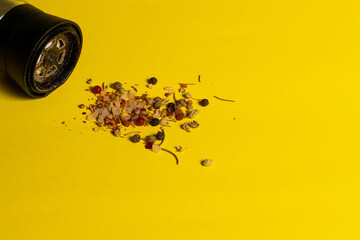 Spicy himalayan salt and pepper mill salt shaker, isolated on yellow background. Copy space for text message.