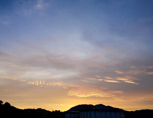 Obraz premium Beautiful view of sunset sky with dramatic light ,silhouette view of mountain and building
