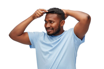 beauty, grooming and hairstyling concept - happy smiling african american man brushing hair with comb over white background