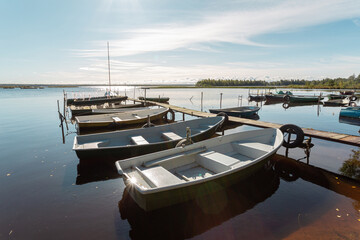 Fototapeta na wymiar Picturesque landscape with fishing boats under the sun on an early autumn day in Russia.