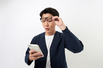 Surprised happy Asian man holding phone looking at cellphone read good news over white background.
