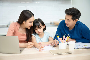 Asian father, mother and daughter doing home work togather in living room, education at home and family concept