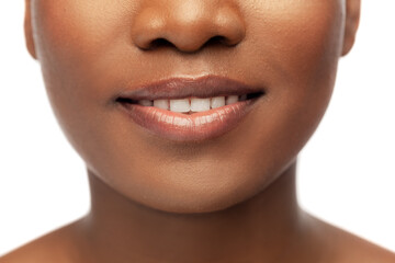 beauty, dental care and people concept - close up of face of beautiful smiling young african american woman over white background