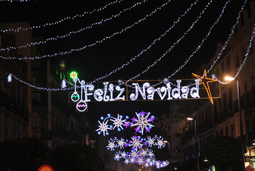Feliz Navidad. Calle céntrica iluminada con bombillas de Navidad . Sevilla Andalucía España