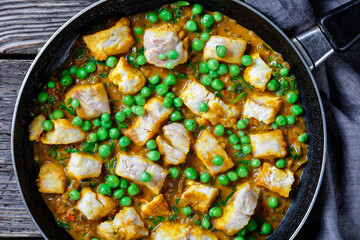 fish curry with green peas, top view