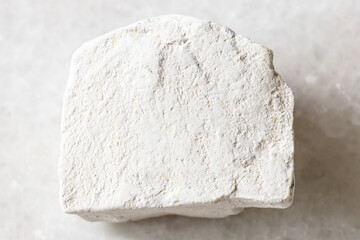 closeup of sample of natural mineral from geological collection - unpolished Chalk stone on white...