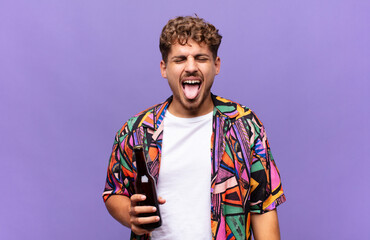 young man with cheerful, carefree, rebellious attitude, joking and sticking tongue out, having fun....