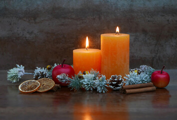 Brennende Kerzen mit Zimtstangen und Äpfeln