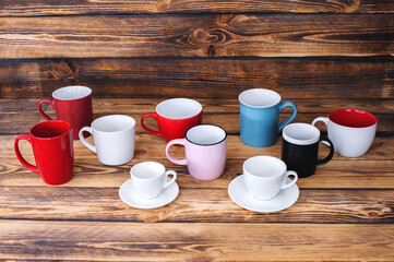 multicolored cups on a dark wood texture background