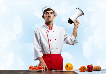Young chef standing with megaphone in hand