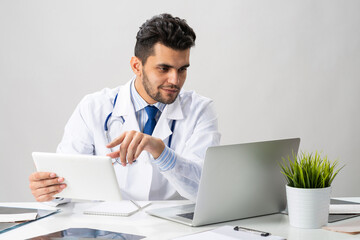 Young arab internist working with tablet computer