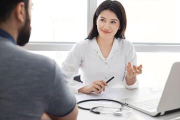 Fototapeta premium Beautiful female doctor consulting patient