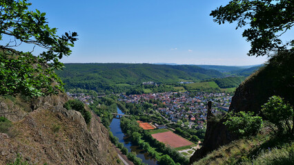 Beautiful view from rock formation Rotenfels ("red rock") over Nahe river valley and Bad Münster am Stein-Ebernburg, part of Bad Kreuznach, Germany with castle in background and blue sky.