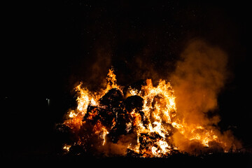 Hot red burning large fire with the black starry night sky.