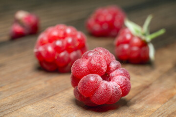 Ripe red raspberries on a wooden table close up