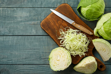Chopped cabbage on blue wooden table, flat lay. Space for text
